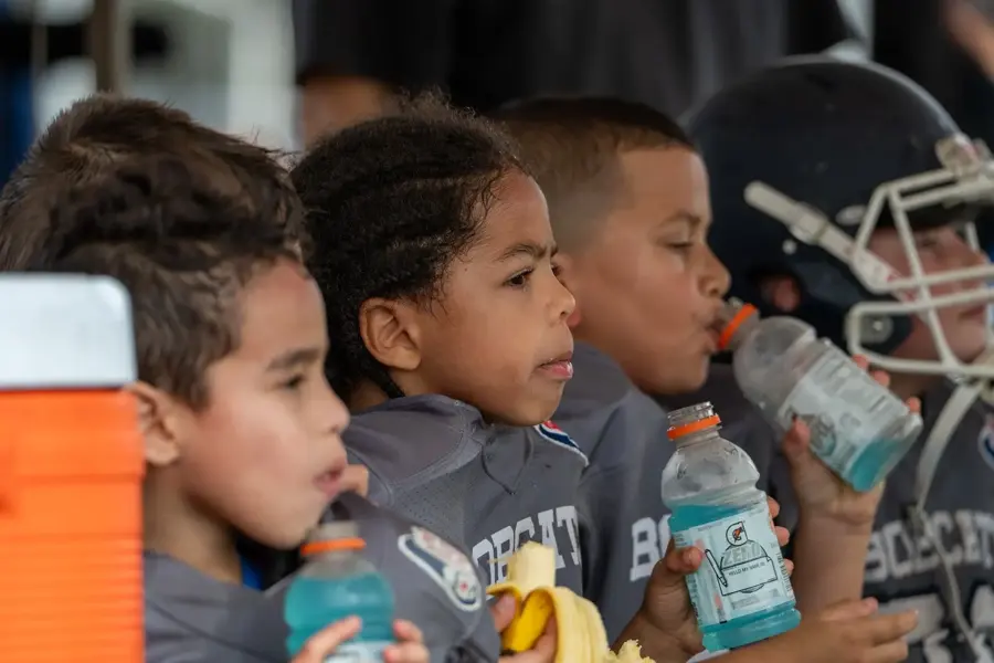 Young Bobcats grabbing a water break on the sideline