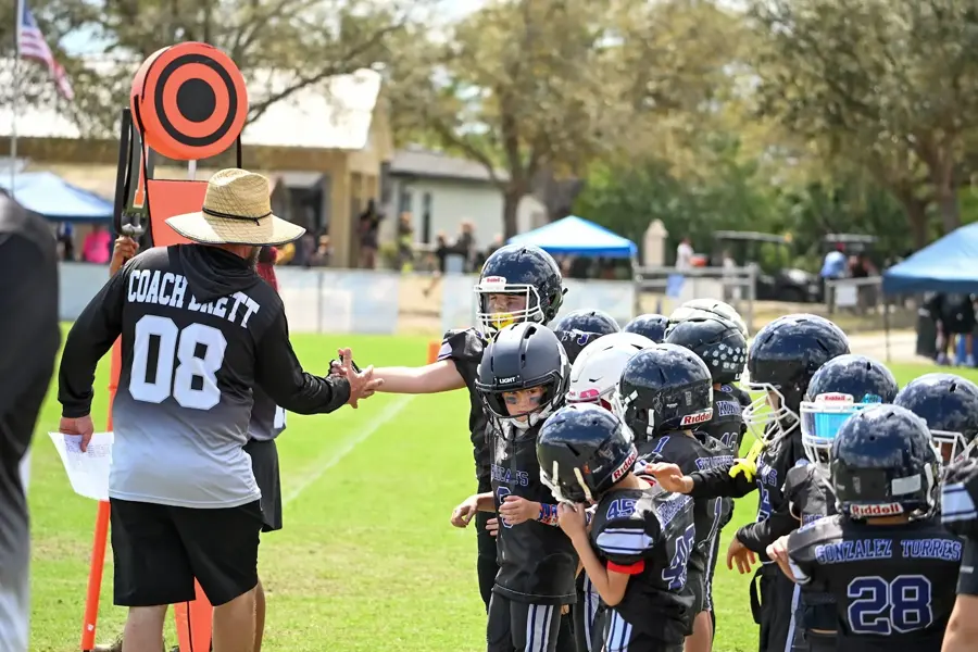 Coach high-fiving the line of Bobcats players after a drill