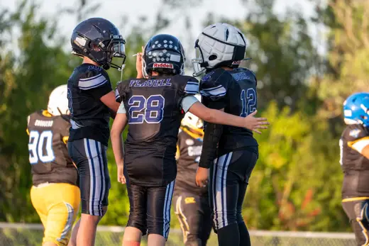10U Bobcats teammates walking arm in arm on the sideline