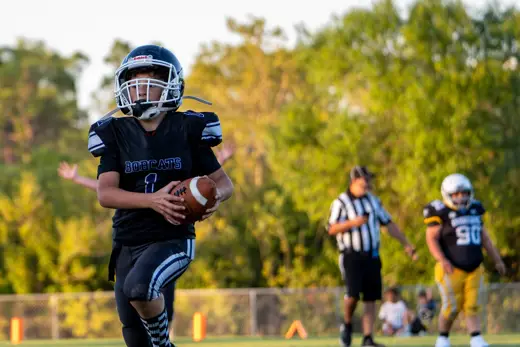 10U Bobcats quarterback surveying the field with the ball