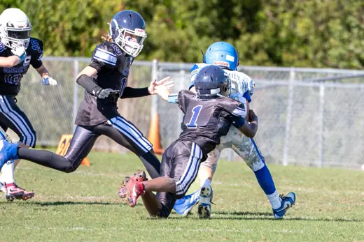 12U Bobcats ball carrier hurdling a defender