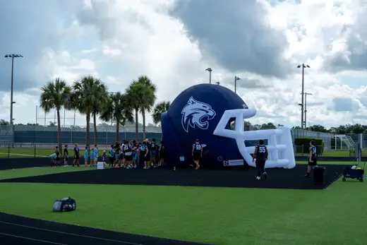 Wide view of the inflatable Bobcats helmet under the palm trees at training camp
