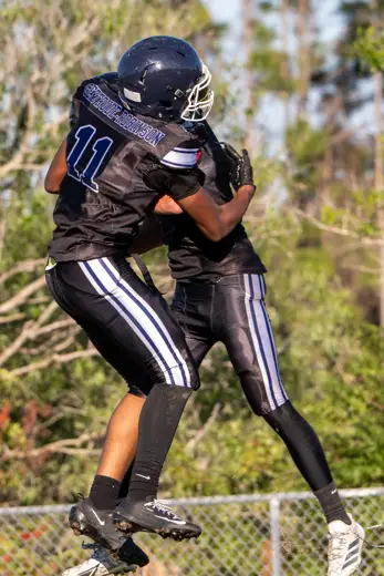 Two Bobcats celebrating with a leaping hug