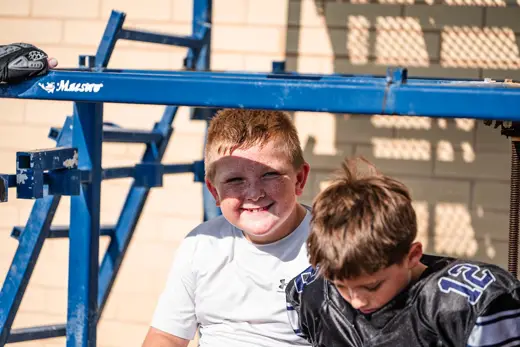 Two young Bobcats fans smiling on the sideline