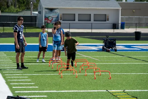 Athletes running agility ladder drills at training camp